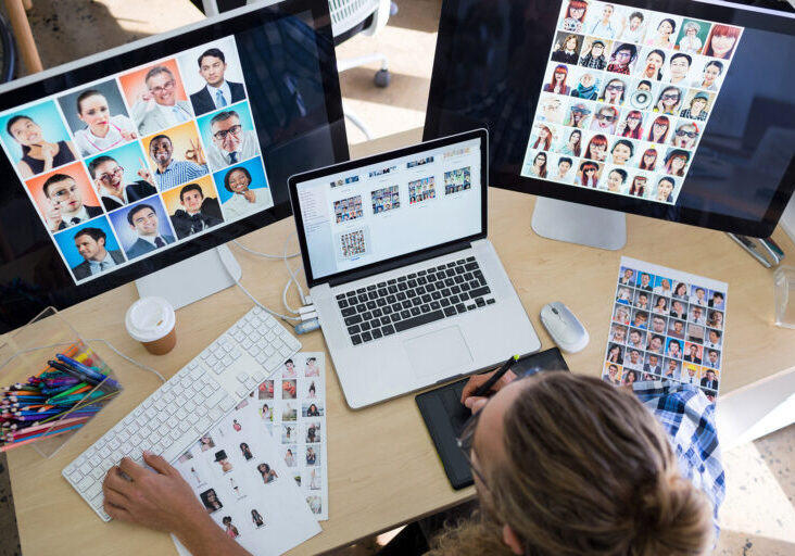 Male executive working over laptop and graphic tablet at his desk in office