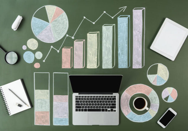 top view of laptop and business charts with cup of coffee and smartphone, laptop computer