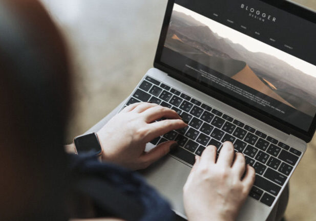 Blogger typing onto a computer screen